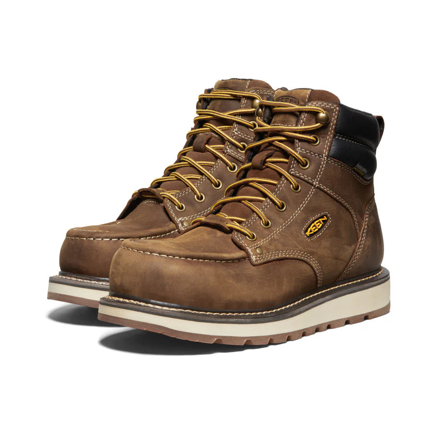 Pair of brown work boots with gold laces on a white background