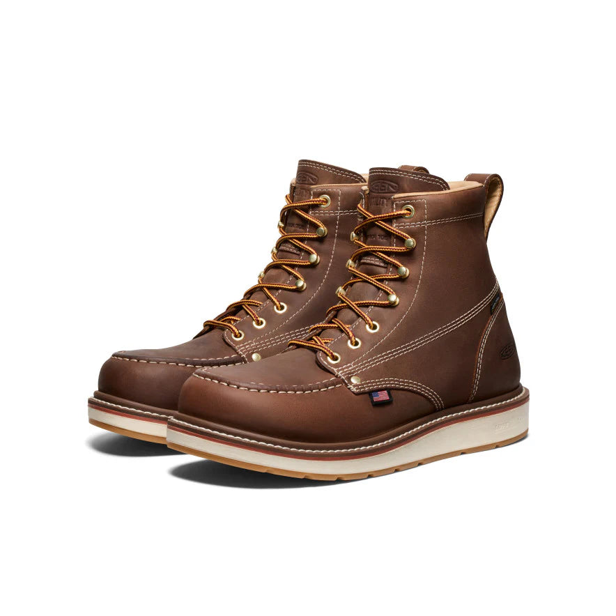Pair of brown leather boots with white soles on a white background