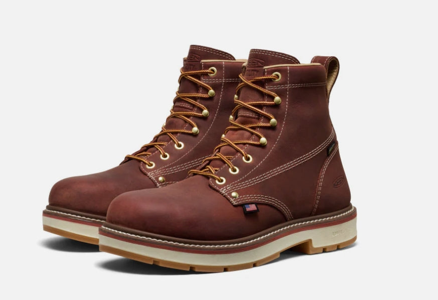 Pair of brown leather boots with gold laces on a white background