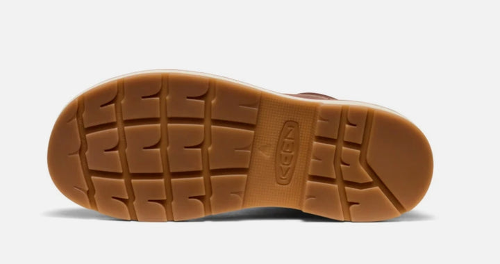 Brown sole of a shoe with a visible brand logo on a white background