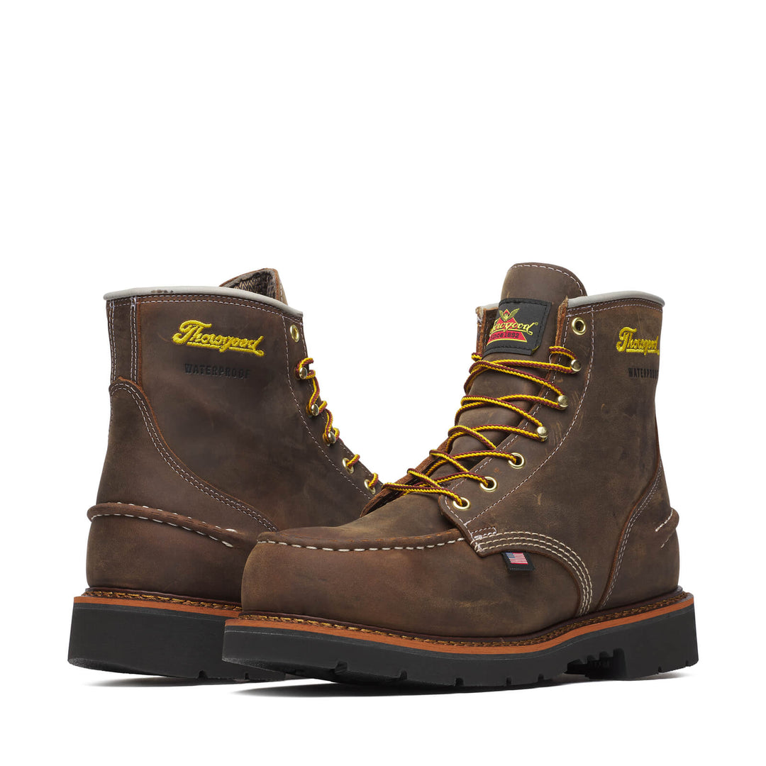 Two boots facing opposite directions with yellow laces on a white background. 