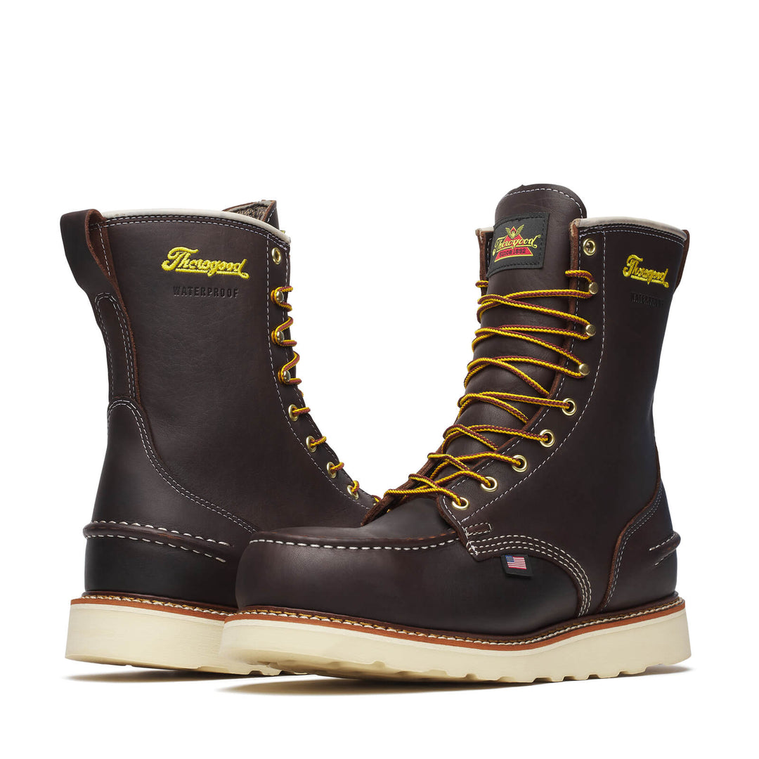 Pair of Thorogood boots with yellow laces on a white background