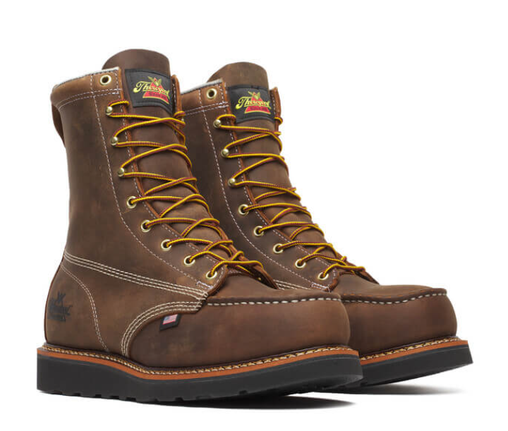 Pair of brown work boots with yellow laces on a white background