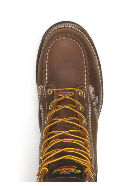 Brown work boot with yellow laces on a white background