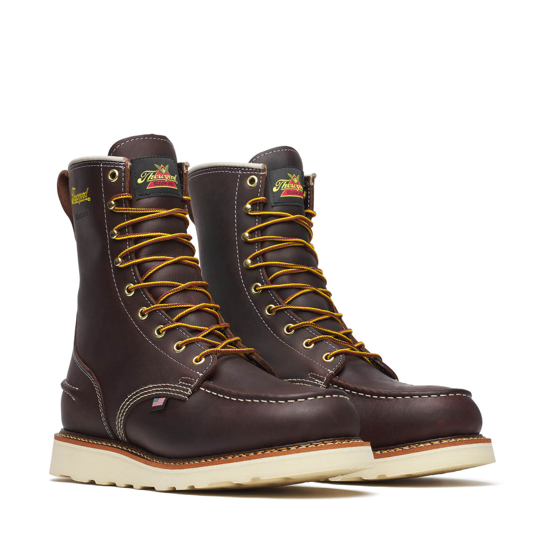Pair of brown leather boots with yellow laces on a white background