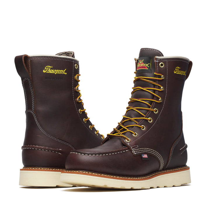 Pair of Thorogood leather boots with yellow laces on a white background
