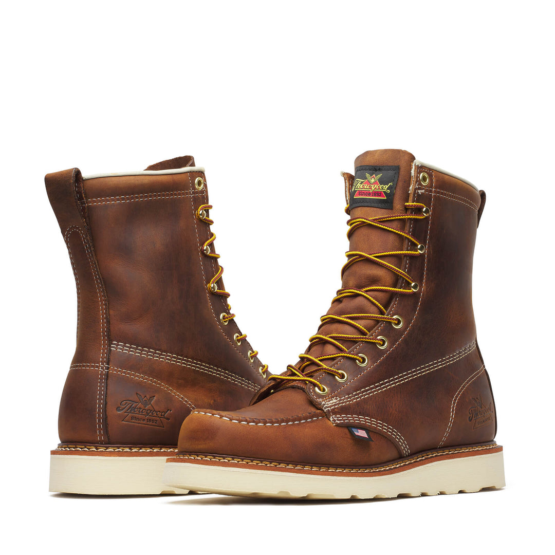 Pair of brown leather boots with yellow laces on a white background