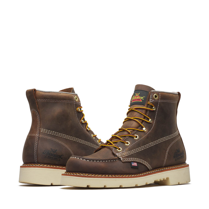 Pair of brown leather boots with gold laces on a white background