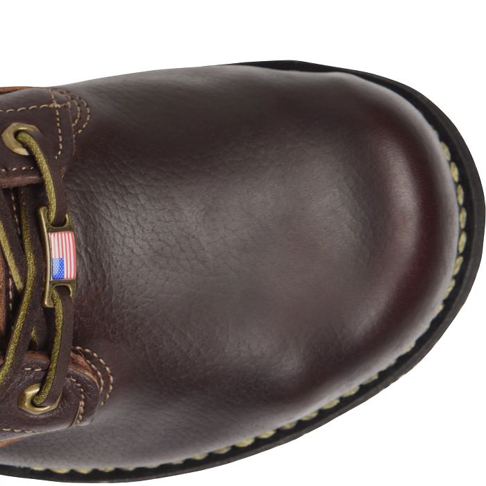 A close up view of a brown boot toe with a white background. 