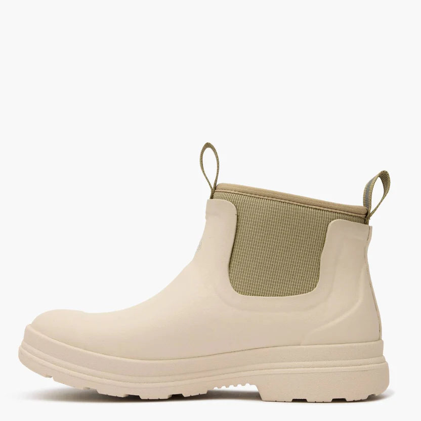 Beige rubber boot with a green lining on a white background